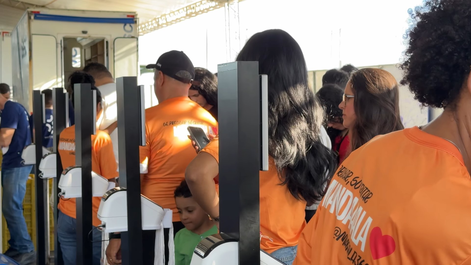 Fileira de equipamentos da Facedoor em operação na entrada do evento, com público passando